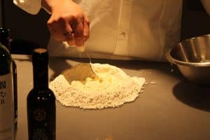 Gianluca Casini zeigt, wie man den Teig mit Olivenöl und warmem Wasser anrührt.