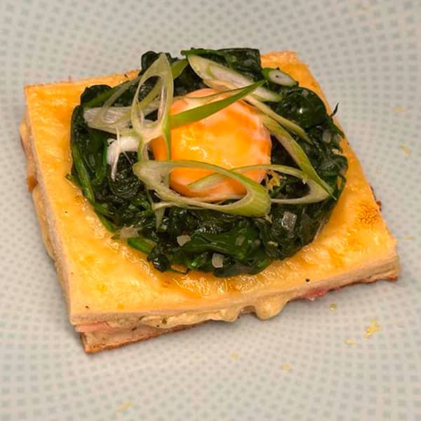 Croque Madame ist ein französisches Frühstücksgericht mit Toast, Käse, Schinken und Spinat.