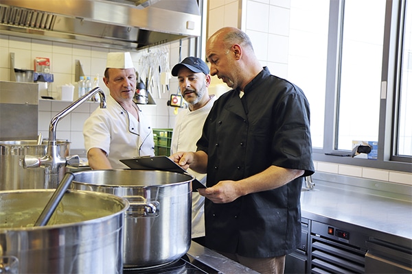 Teambesprechung in der Küche von Kantar - im Vordergrund Küchenleiter Christian Klinger (Quelle: Hercht)