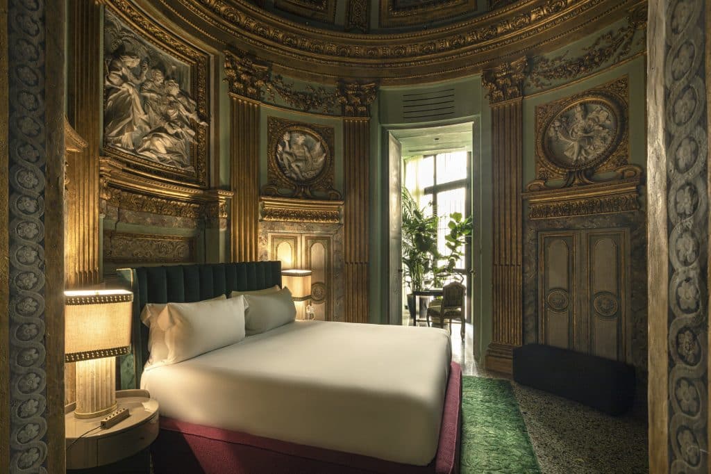Blick in eines der Schlafzimmer des Palazzo Vilòn in Rom, in dem barocke Elemente für eine stimmige Atmosphäre sorgen.
