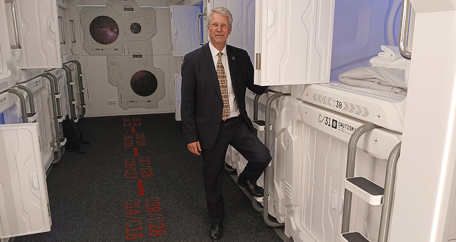 Thomas Reiter vor den Schlafkapseln des neuen Studierendenhostel im Weltraumlook des Studierendenwerks Frankfurt/M.