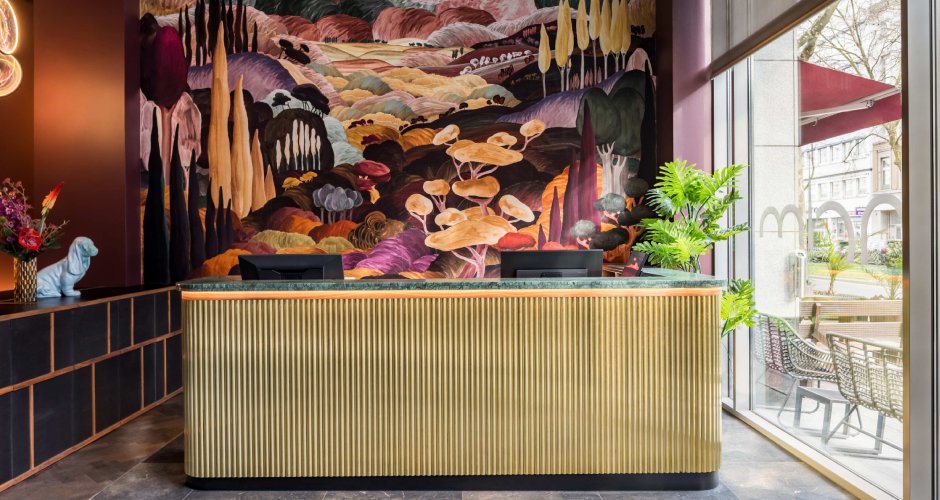 Eines der Highlights des Hotel Amano Düssedorf empfängt die Gäste gleich bei ihrme Besuch: die Rezeption mit Chenile Tapete.