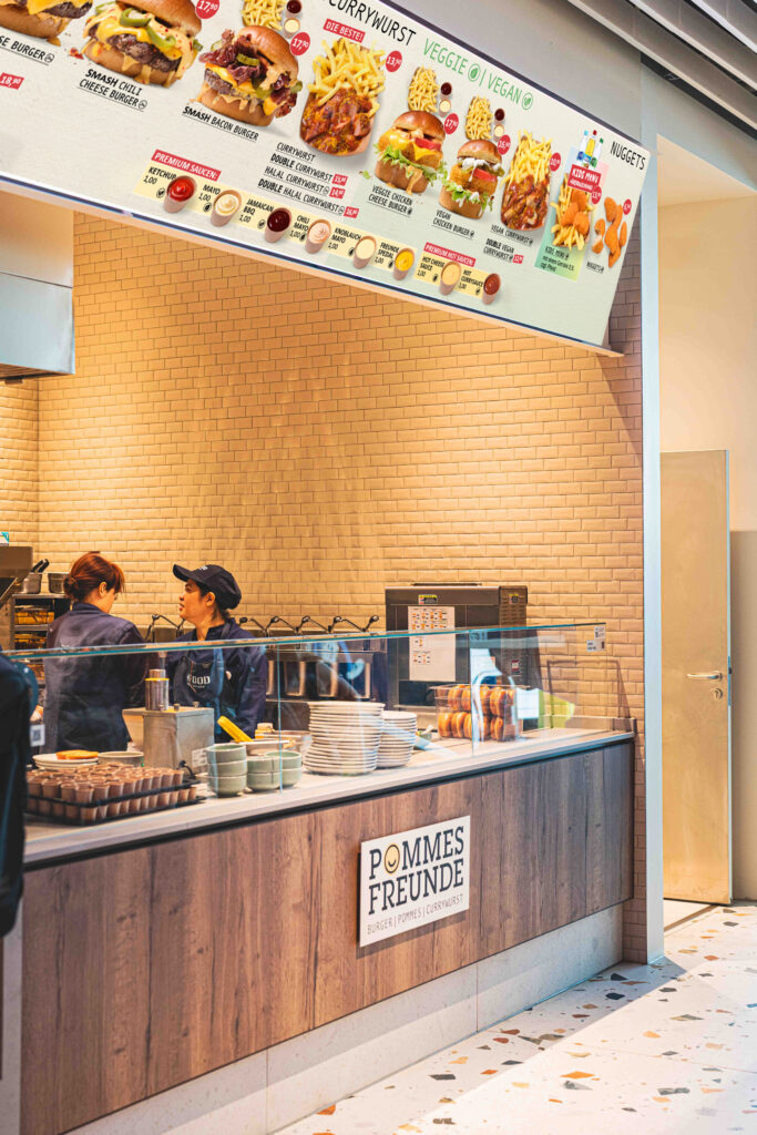 Pommes Freunde bringt frische Pommes, Smash Burger und Currywurst ins neue Foodcourt-Konzept des Flughafen München.