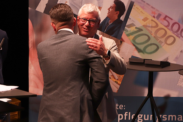 Der Abteilungsleiter Hochschulgastronomie des Studierendenwerks Karlsruhe gratuliert Tobias Grau.