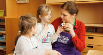 Sarah Wiener probiert Apfelringe mit Kitakindern im Rahmen von Ich kann kochen